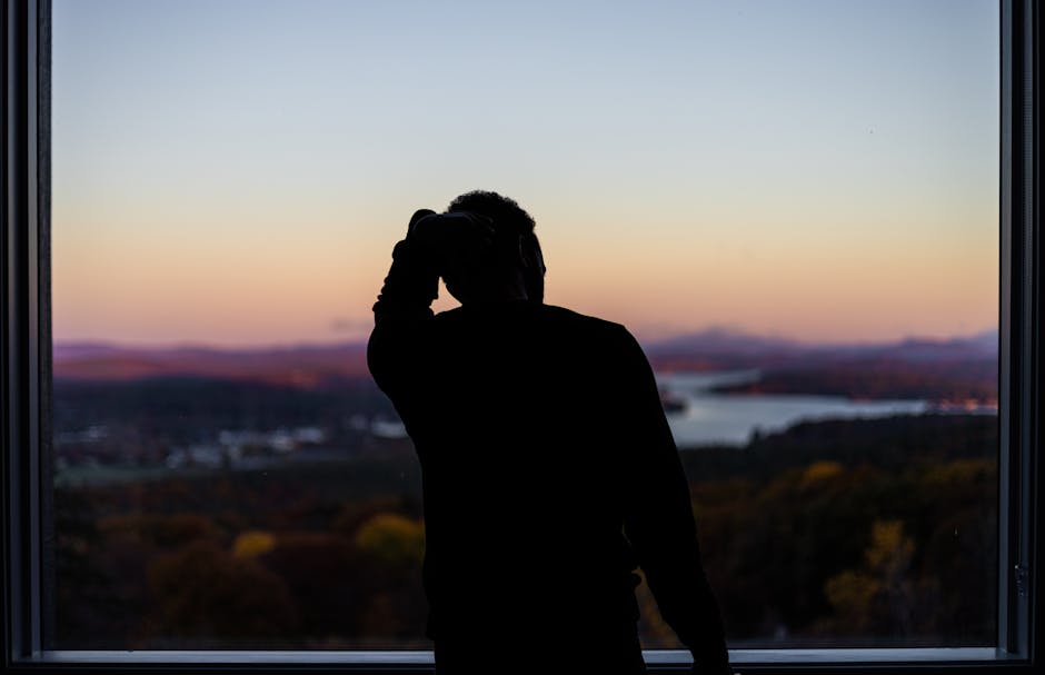 一个人坐在窗边沉思，黄昏光线，城市剪影，安静内省的氛围